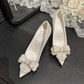 White satin stiletto wedding shoes with pointed toe, pearl bow detail, by LYNHURD for brides.