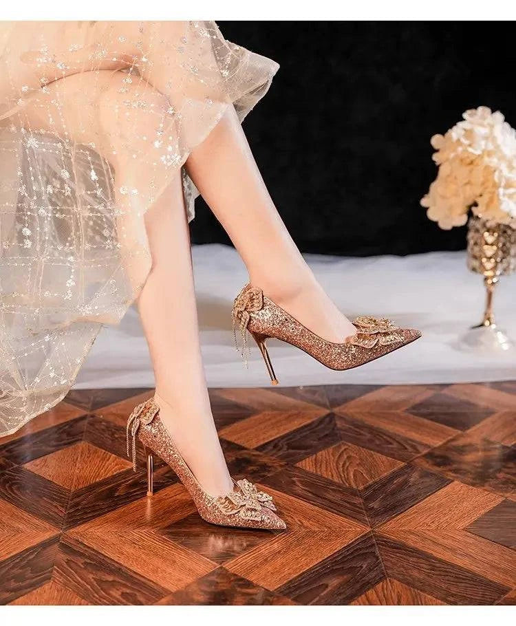 Silver high heel pumps for women by LYNHURD, featuring a pointed toe and bow detail, adorned with sparkling French crystals.